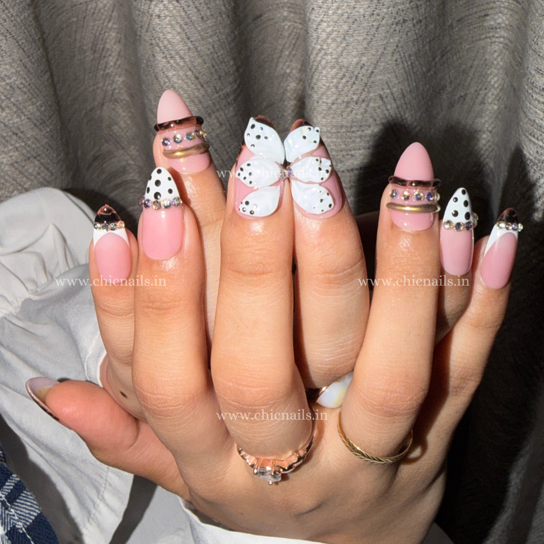 Pink coquette press-on nails with 3D flower, rhinestones, bangle nail rings, polka dots, and zebra print design by Chic Nails India