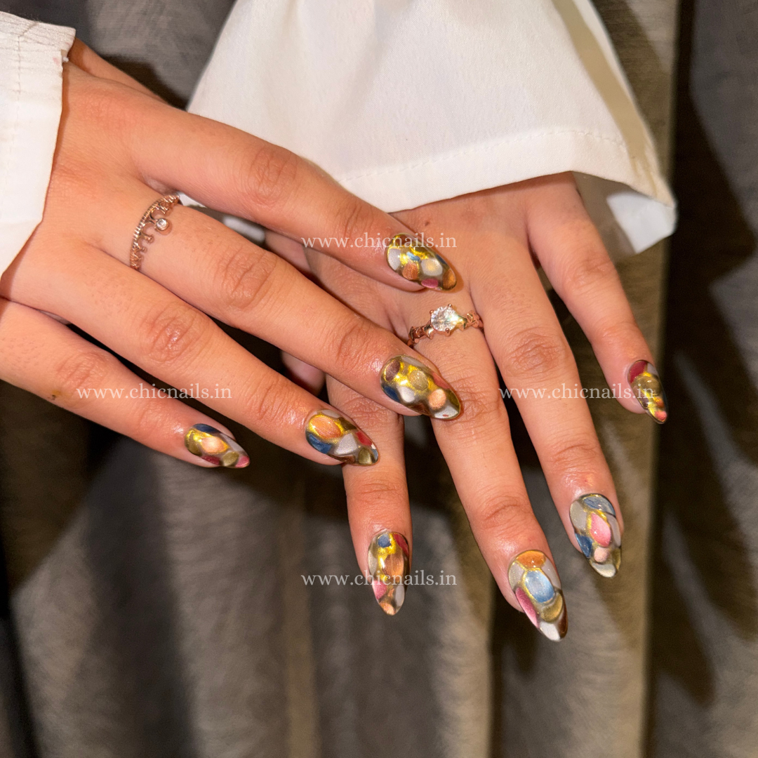 Abstract stained glass mosaic press-on nails with multi-color design, cat eye effect, and chrome detailing by Chic Nails India