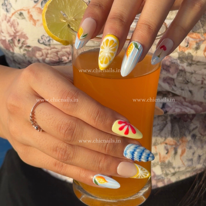 Summer Splash press-on nails with details of lemon, cherry, and ocean wave nail art in bright summer colors by chicnails India