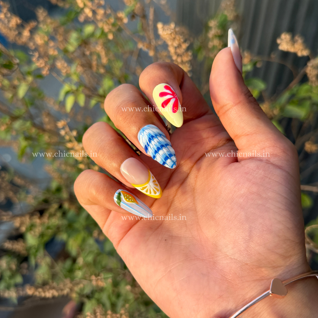 Summer Splash press-on nails with details of lemon, cherry, and ocean wave nail art in bright summer colors by chicnails India