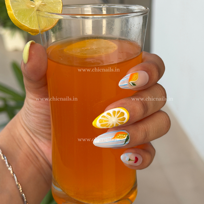 Summer Splash press-on nails with details of lemon, cherry, and ocean wave nail art in bright summer colors by chicnails India