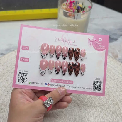 Safari Chic press-on nails featuring zebra French tips, leopard print accents, nude ombre base, and floral nail art design, displayed on Chic Nails packaging.