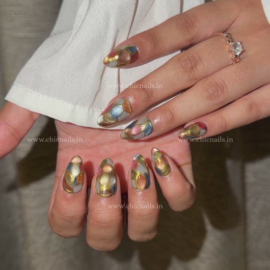Abstract stained glass mosaic press-on nails with multi-color design, cat eye effect, and chrome detailing by Chic Nails India