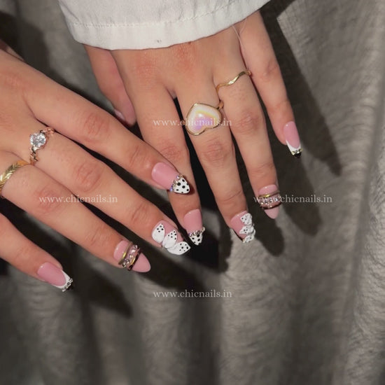 Pink coquette press-on nails with 3D flower, rhinestones, bangle nail rings, polka dots, and zebra print design by Chic Nails India