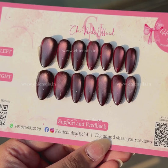 Wine Magic dark red magnetic cat-eye press-on nails with a glossy wine finish and glowing effect by Chic Nails Official.