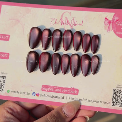 Wine Magic dark red magnetic cat-eye press-on nails with a glossy wine finish and glowing effect by Chic Nails Official.